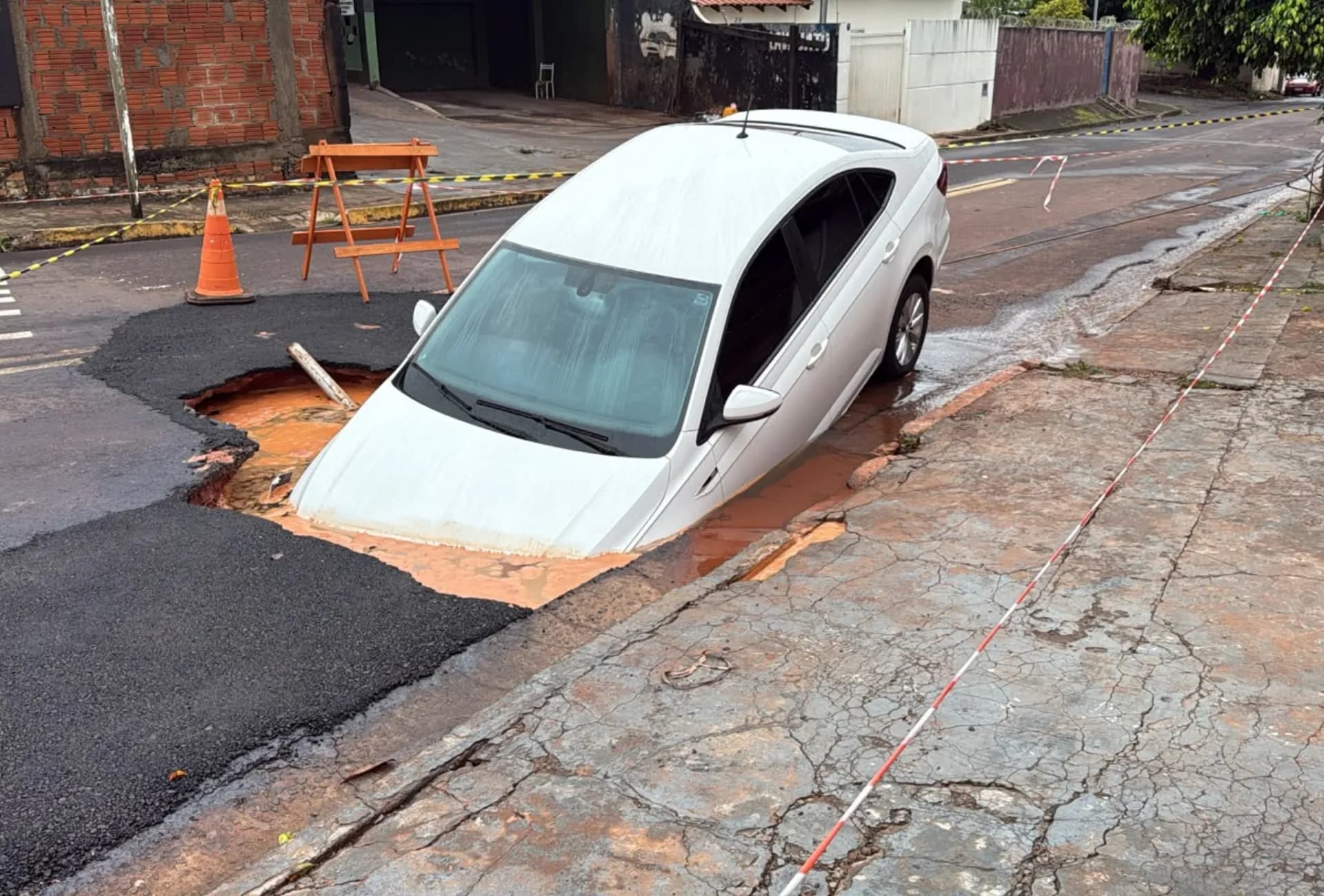 Carro é engolido por buraco após forte chuva em Campo Grande